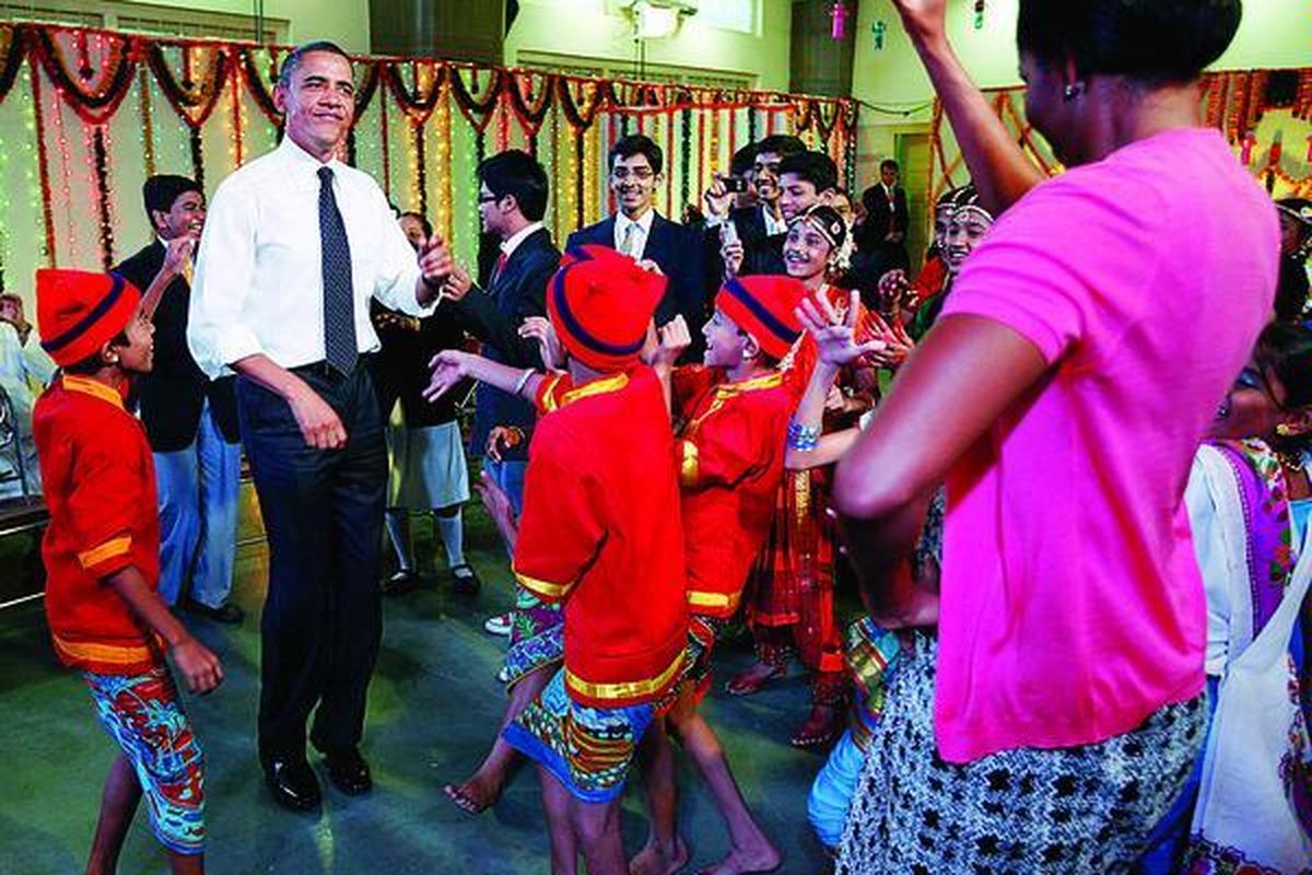 Presiden Amerika Serikat Barack Obama dan Michelle Obama saat ikut menari bersama pelajar-pelajar India dalam kunjungannya di sebuah sekolah menengah India di Mumbai, Minggu (7/11).