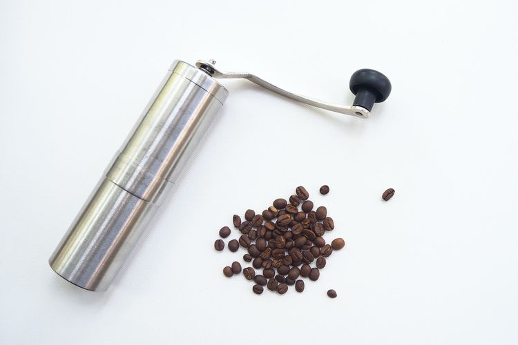 Ilustrasi coffee grinder atau alat penggiling biji kopi. 