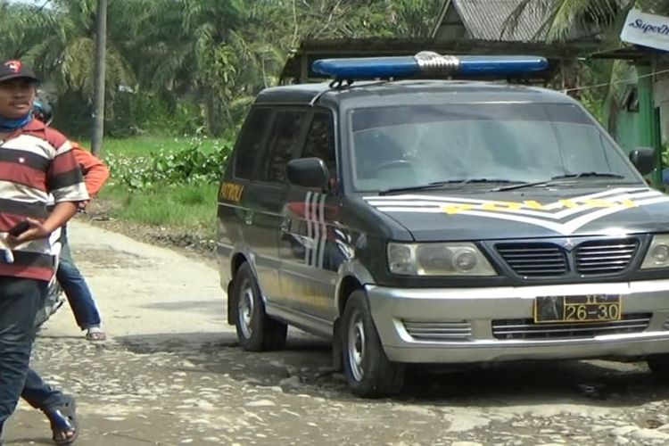 Seorang berjalan di lokasi kejadian penembakan tiga orang terduga teroris di Jalan Desa Kota Datar, Kecamatan Hamparan Perak, Deli Serdang pada Sabtu (16/11/2019).