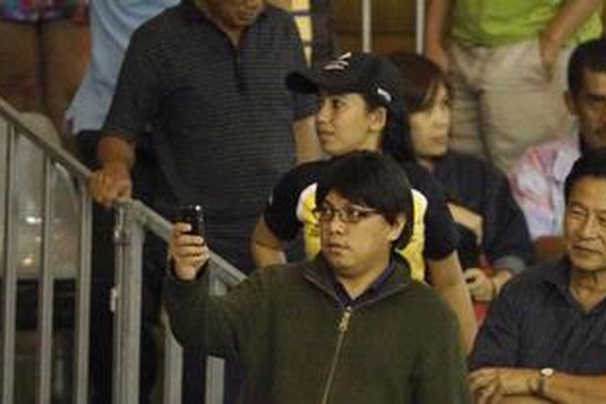 Seorang penonton yang mirip tersangka kasus mafia pajak, Gayus HP Tambunan tengah menggunakan ponselnya untuk merekam momen dalam pertandingan tenis antara Daniela Hantuchova melawan Yanina Wickmayer dalam Commonwealth Bank Tournament of Champions di Nusa Dua, Bali, Jumat (5/11/2010). 