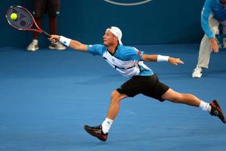 Petenis Australia, Lleyton Hewitt berusaha menjangkau bola kiriman petenis Swiss, Roger Federer, saat keduanya bertemu pada final Brisbane International, Minggu (05/01/2014).