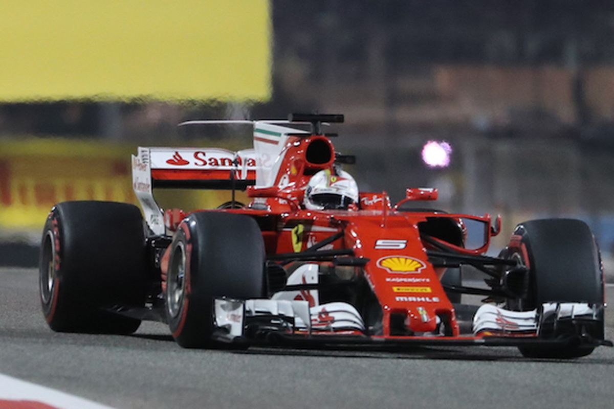 Pebalap Ferrari asal Jerman, Sebastian Vettel (depan), memacu mobilnya di depan pebalap Mercedes asal Finlandia, pada balapan GP Bahrain di Sirkuit Internasional Bahrain, Sakhir, Minggu (16/4/2017).