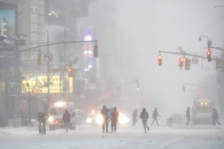 Warga berjalan melalui Times Square New York, AS, selama badai salju pada Sabtu (29/1/2022). Sebuah badai yang kuat menyapu Pantai Timur AS pada Sabtu.