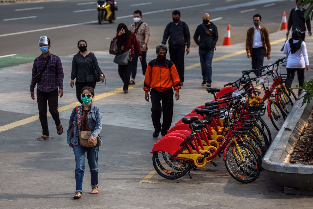 Pekerja yang menggunakan masker saat berjalan menuju kantor masing-masing di Jalan M.H Thamrin, Jakarta Pusat, Senin (14/9/2020). PSBB kembali diterapkan tanggal 14 September 2020, berbagai aktivitas kembali dibatasi yakni aktivitas perkantoran, usaha, transportasi, hingga fasilitas umum.