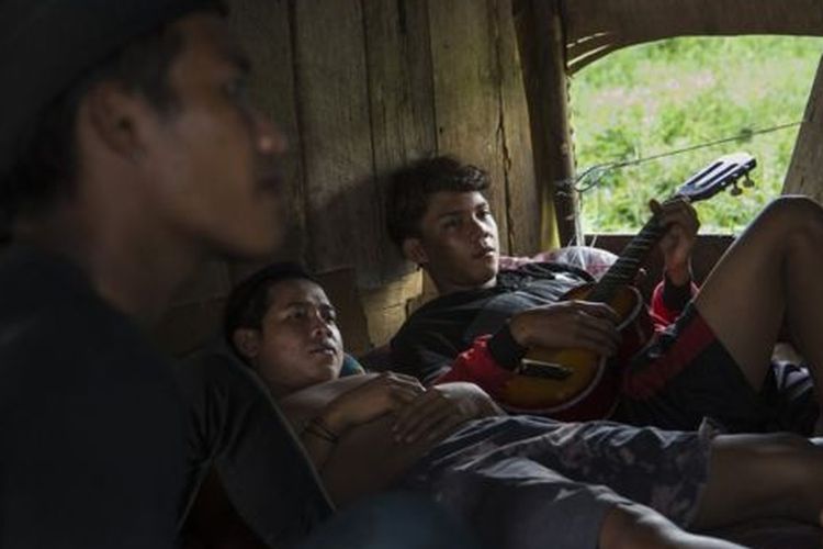 Tiga pekerja pertambangan di Samarinda beristirahat di gubuk berbahan kayu. Sebagian besar pemerintah daerah di Kaltim menggantungkan pemasukan dari industri batu bara. 