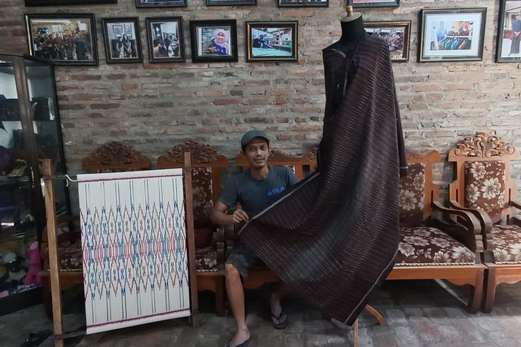 Erwin, perajin kain tenun ikat Bandar Kidul Kota Kediri, Jawa Timur, menunjukkan contoh kain tenun yang dipakai Presiden Joko Widodo di ajang Trade Expo Indonesia ke 37.