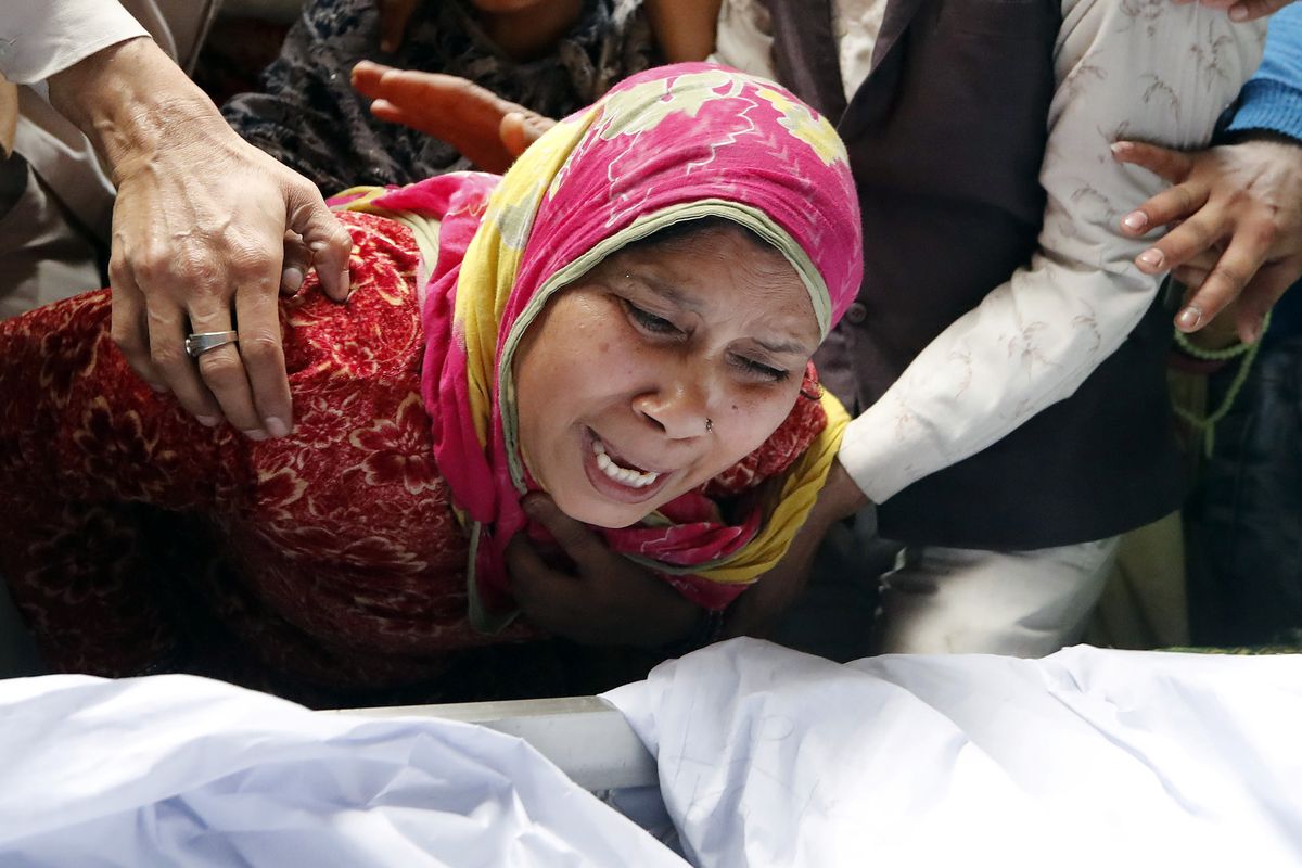 Seorang wanita menangisi anaknya, Hashim Ali, yang terluka saat bentrokan terjadi di New Delhi, India, Selasa (25/2/2020). Kerusuhan terjadi akibat UU Kewarganegaraan India yang kontroversial.