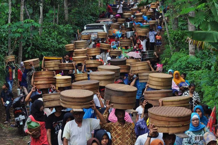 Terlihat beberapa masyarakat di daerah Jawa yang berbondong-bondong membawa bungkusan makanan hasil bumi ke makam leluhur.