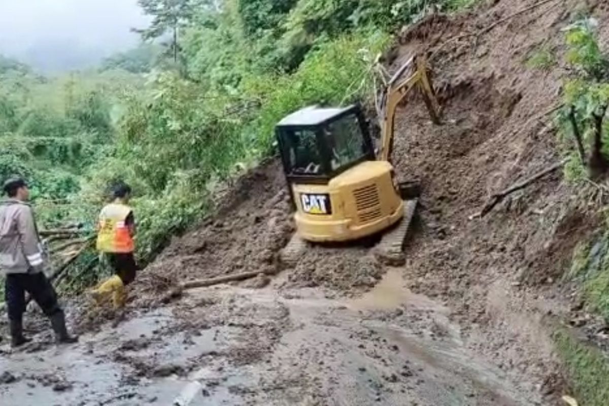 Satu unit alat berat sedang membersihkan material longsor di Jalan Tamanjaya-Palangpang, Tanjakan Cipeucang, Kecamatan Ciemas, Sukabumi, Jawa Barat, Kamis (16/2/2023).
