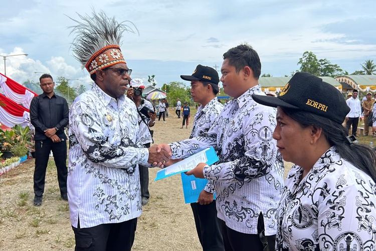 Bupati Keerom, Piter Gusbager, saat memberikan penghargaan kepada guru di sela-sela peringatan hari guru yang berlangsung di lapangan Swakarsa, Distrik Arso, Kabupaten Keerom, Papua, Senin (27/11/2023).