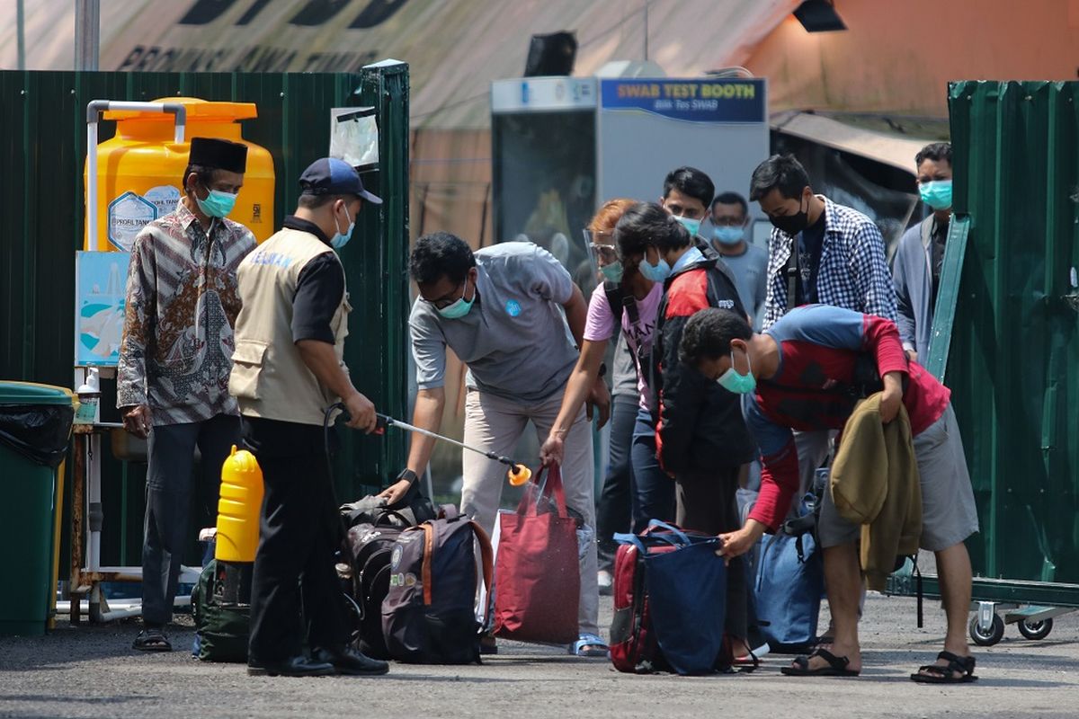 Petugas menyemprotkan larutan disinfektan ke barang bawaan pasien COVID-19 yang telah sembuh di Rumah Sakit Lapangan Kogabwilhan II Jalan Indrapura, Surabaya, Jawa Timur, Minggu (14/3/2021). Rumah sakit yang diresmikan pada Selasa (2/6/2020) tersebut sampai saat ini telah berhasil menyembuhkan sebanyak 6.631 orang pasien COVID-19. ANTARA FOTO/Didik Suhartono/aww.