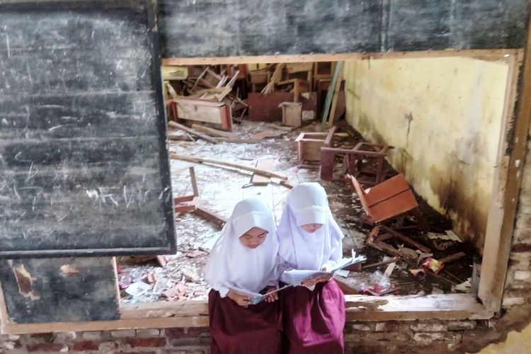 Dua orang murid SD Negeri Bina Warga Karangnunggal, Kecamatan Cbeber, Kabupaten Cianjur, Jawa Barat, sedang belajar di kelas dengan kondisi sangat tidak layak.