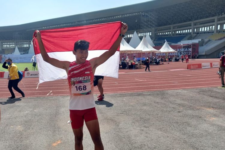 Atlet para-ateltik Indonesia Sapto Yogo Purnomo membentangkan bendera Indonesia setelah berlaga di nomor lari 100 meter kategori T37 putra ASEAN Para Games 2022 di Stadion Manahan, Solo, Senin (1/8/2022) pagi WIB.