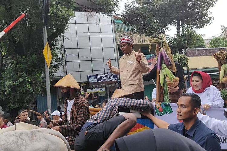 Gerobak sapi yang mengangkut cawapres nomor urut 3 Mahfud MD tepat berada di belakang gerobak capres Ganjar Pranowo dan keluarganya, saat hajatan rakyat terakhir di Kota Solo, Jawa Tengah, Sabtu (10/2/2024).