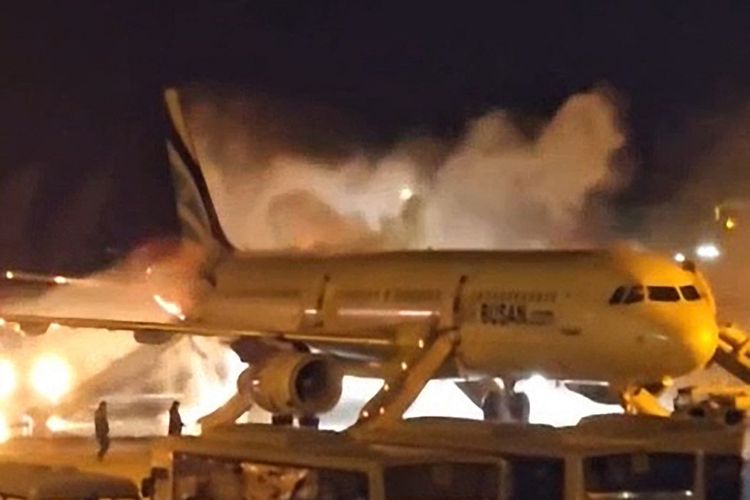 Penampakan pesawat Air Busan terbakar di Bandara Internasional Gimhae, Busan, Korea Selatan, Selasa (28/1/2025). Sebanyak 176 orang dievakuasi, tiga di antaranya luka-luka.