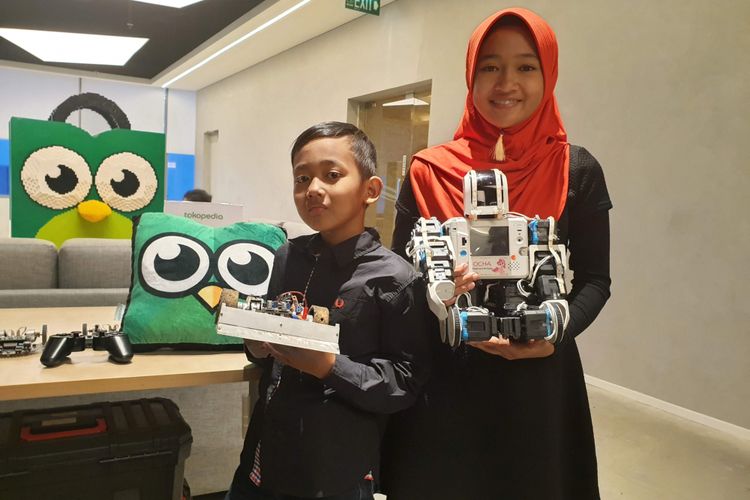 (ki-ka) Syahrozad Zalfa Nadi (Ocha ) dan Avicenna Roghid Putra Sidik (Ave) saat memamerkan koleksi robot karya mereka di acara Ngobrol Aja Dulu: Tech Kids Tokopedia dan Komunitas Mata Kita di Jakarta.
