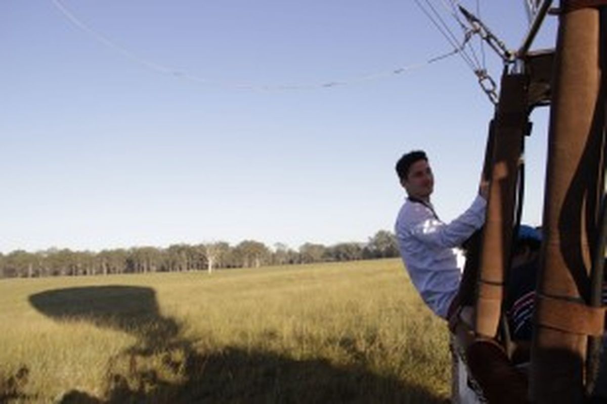 Nino Fernandez masih duduk di pinggir keranjang sesudah balon udara yang ditumpanginya mendarat sempurna di padang rumput Gold Coast Hinterland, Queensland, Australia, 17 April 2013.