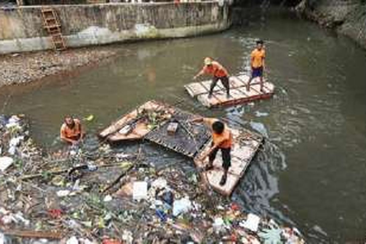 Petugas Unit Pengelola Kebersihan Badan Air, Taman, dan Jalur Hijau Dinas Kebersihan DKI Jakarta mengangkut sampah di pertemuan sodetan Kali Grogol dengan Kali Pesanggrahan, di kawasan Tanah Kusir, Jakarta Selatan, Rabu (1/6). Para petugas tersebut bertanggung jawab atas kebersihan aliran sungai dari sampah. 