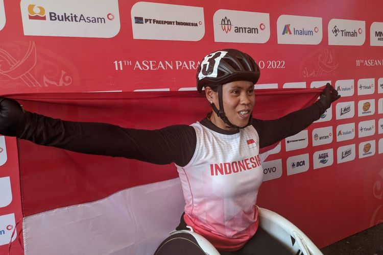 Maria Goreti Samiyati mengibarkan bendera Merah Putih usai memenangi lomba wheelchair 400 meter putri ASEAN Para Games 2022 yang digelar di Stadion Manahan, Solo, pada Kamis (4/8/2022).