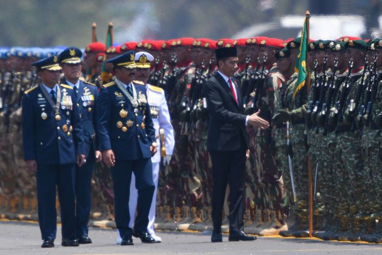 Inspektur upacara, Presiden Joko Widodo (kanan) didampingi Panglima TNI Marsekal TNI Hadi Tjahjanto (ketiga kanan), Kepala Staf TNI AL Laksamana TNI Siwi Sukma Adji (kedua kanan) dan Kepala Staf TNI AU Marsekal TNI Yuyu Sutisna (kiri) menyalami pasukan usai Upacara Perayaan HUT Ke-74 TNI di Lanud Halim Perdanakusuma, Jakarta Timur, Sabtu (5/10/2019). 