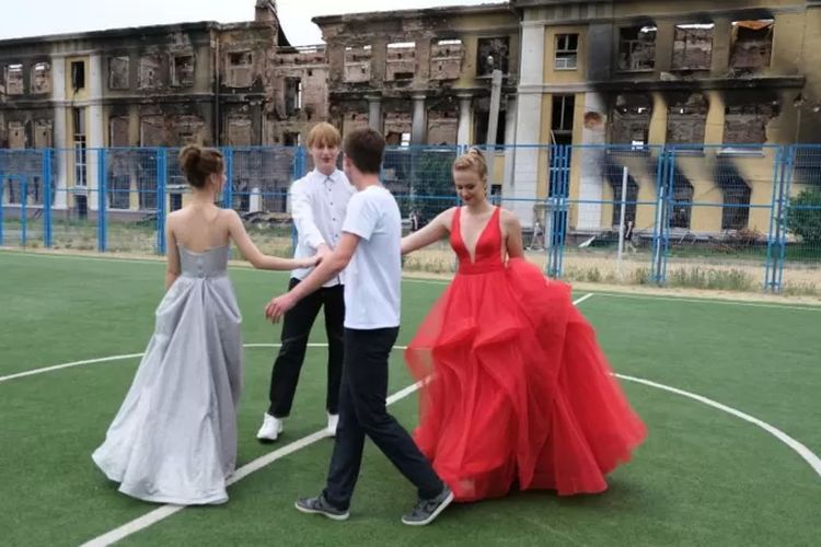 Students in Ukraine celebrate graduation in the ruins of a school building.