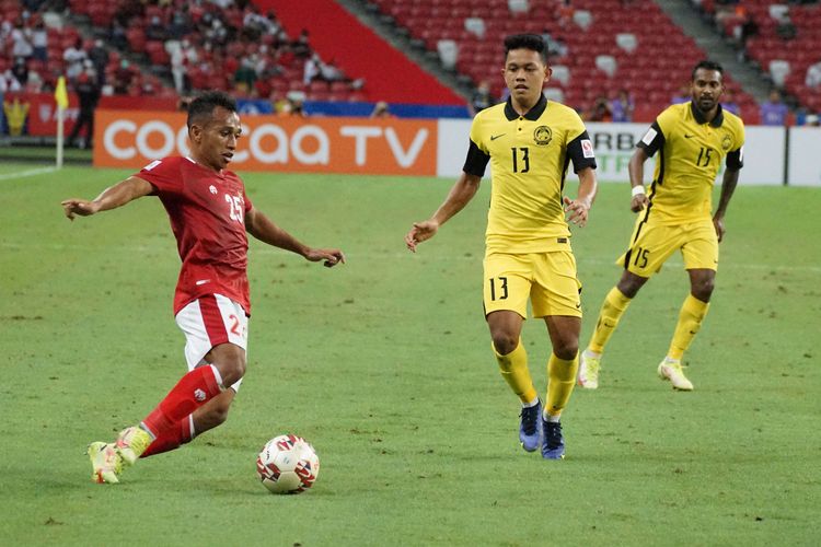 Pesepak bola Timnas Indonesia Irfan Jaya (kiri) berusaha melewati pesepak bola Timnas Malaysia Arif Aiman (tengah) dalam pertandingan grup B Piala AFF 2020 di National Stadium, Singapura, Minggu (19/12/2021). Indonesia menang dengan skor 4-1 dan lolos ke babak semifinal Piala AFF.