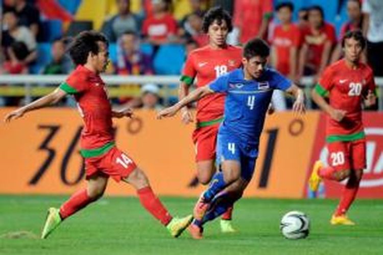 Pemain Thailand Kroekrit Thawikan (tengah) menguasai bola dari bayangan para pemain indonesia pada pertandingan terakhir penyisihan Grup E cabang sepak bola Asian Games 2014, di Incheon Football Stadium, Senin (22/9/2014). Indonesia kalah 0-6.