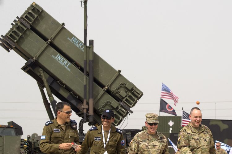 Perwira tentara AS dan Israel berjalan di depan sistem pertahanan rudal Patriot AS selama latihan militer gabungan Israel-AS Juniper Cobra di Pangkalan Angkatan Udara Hatzor Israel pada 8 Maret 2018.