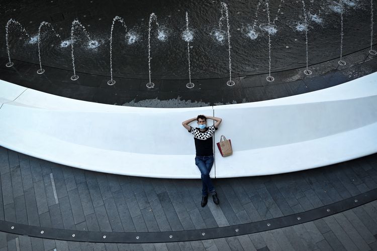 Ilustrasi kehidupan di China: A man rests outside an office building in Beijing on July 15, 2020. (Photo by WANG ZHAO / AFP)