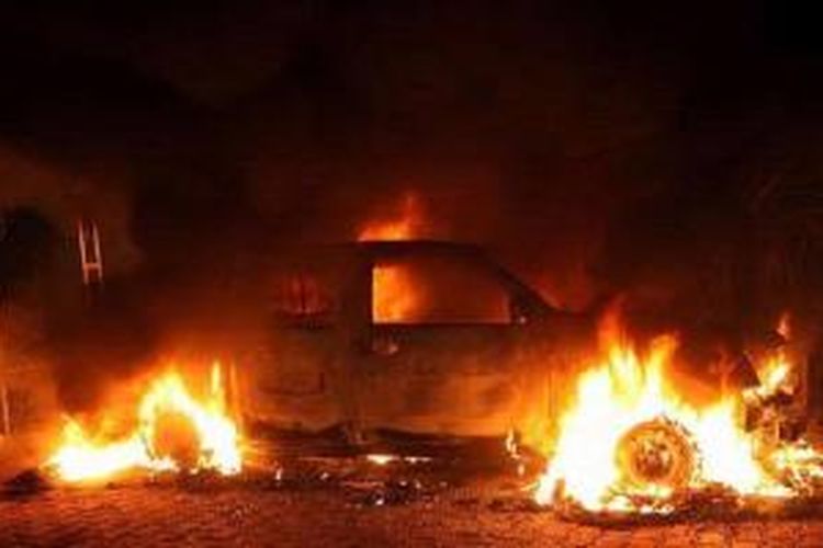 Sebuah mobil dibakar di dekat kantor konsulat AS di Benghazi, Libia yang diserbu massa bersenjata 11 September 2012.