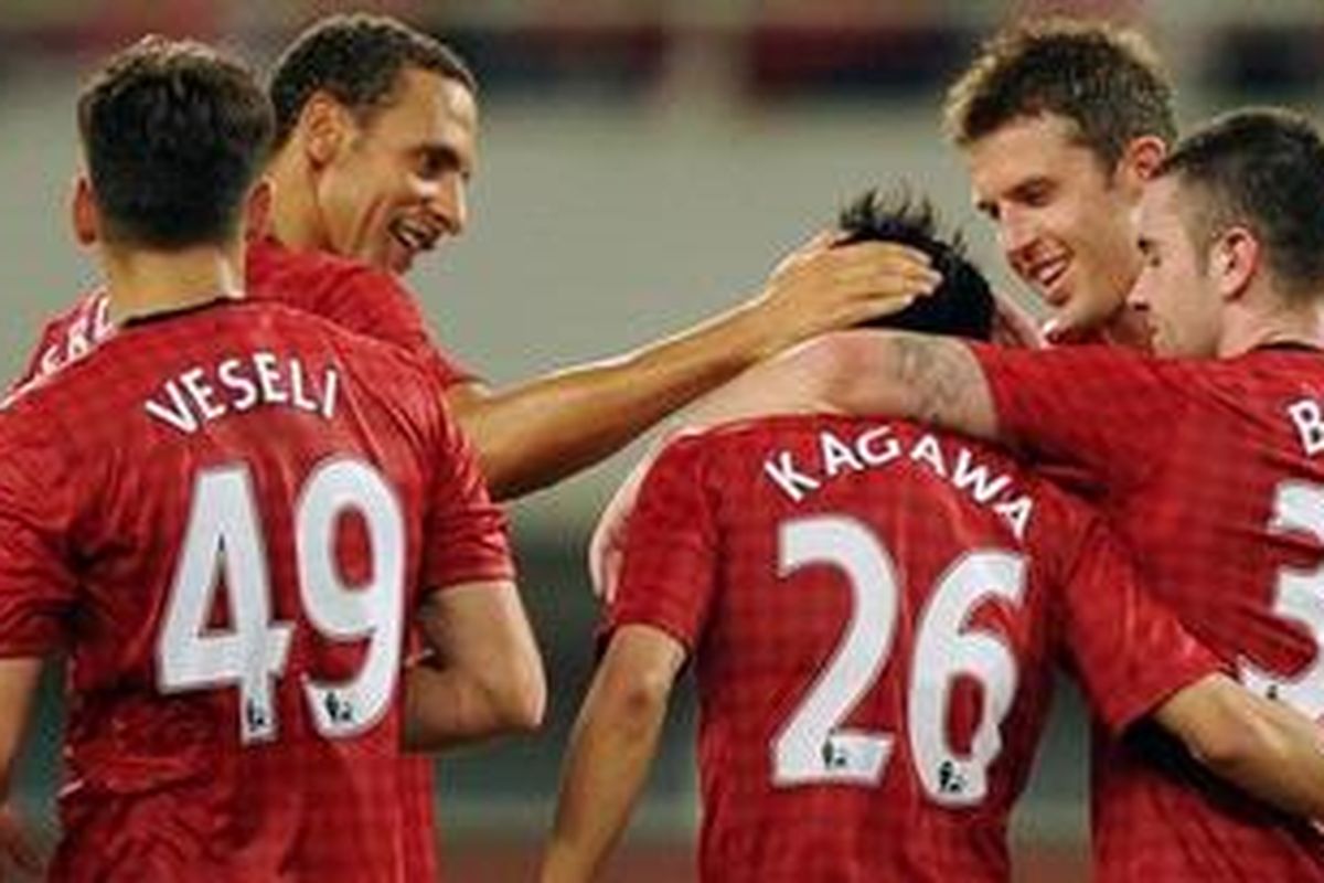 Shinji Kagawa (tengah) disambut rekan-rekannya setelah membobol gawang Shanghai Shenhua dalam laga persahabatan, Rabu (25/7/2012). Golnya memastikan Manchester Unitedf menang 1-0.