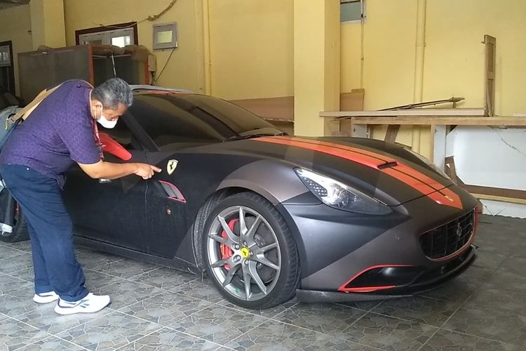 Seseorang menunjuk logo mobil Ferrari pada Kamis (10/3/2022) sore. Mobil milik tersangka Indra Kenz tersebut disita oleh tim Bareskrim Mabes Polri dan kini dititipkan di gudang Ditreskrimsus Polda Sumut.