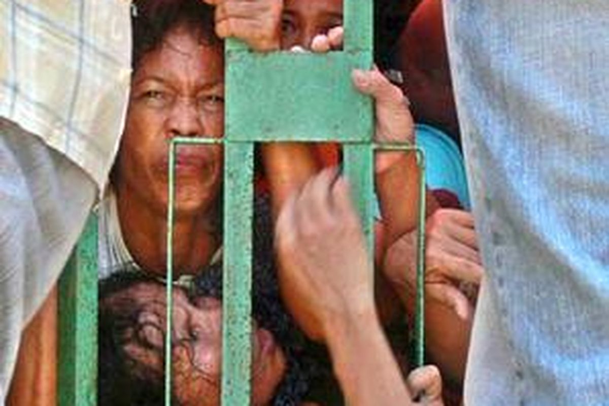 Meringis dengan nafas tersengal ketika terinjak dan terhimpir di pagar ketika berebut zakat dari dermawan bernama H Saikhon di Gang Pepaya, Jalan dr Wahidin, Kelurahan Purutrejo, Purworejo, Kota Pasuruan, Jawa Timur, Senin (15/9).