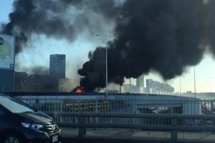 Kepulan asap hitam mengudara setelah sebuah pesawat ringan dengan lima orang di dalamnya jatuh di areal pusat perbelanjaan di Melbourne, Australia, Selasa pagi (21/2/2017).