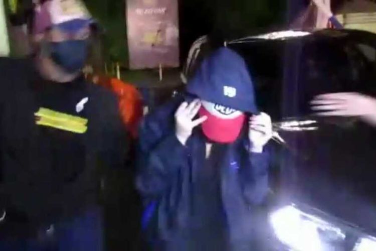 Tangkapan layar video seorang perempuan berinisial H (23) digelandang dari mobil hitam di Polrestabes Medan pada Minggu (12/7/2020) malam. H diamankan di sebuah hotel bersama dengan seorang pria terkait dugaan prostitusi melibatkan artis.