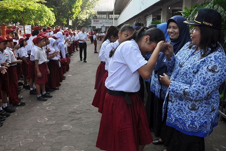 Sejumlah siswa menyalami guru mereka seusai mengikuti upacara di Sekolah Dasar Negeri 060813 Medan, Sumatera Utara, Senin (25/11/2019). Menyalami guru oleh para siswa tersebut dalam rangka memperingati Hari Guru yang serentak dilaksanakan di seluruh Indonesia.