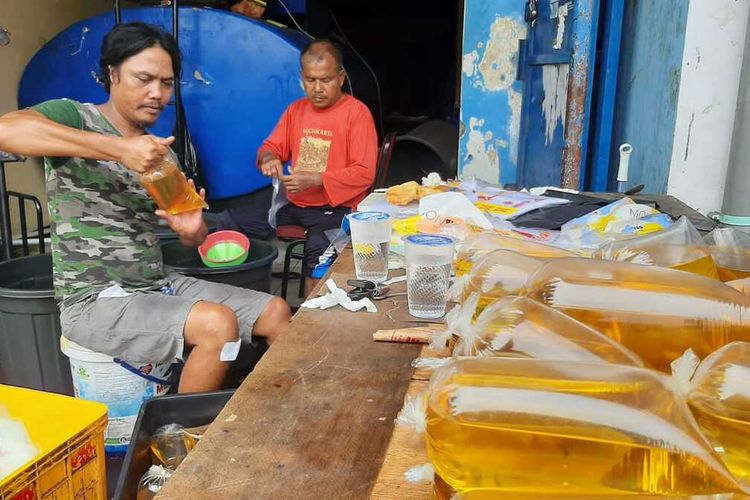 Mampe, penjual minyak goreng curah saat menyiapkan kemasaran satu liter untuk dijual. Tokonya di Jalan Samaun Bakri, Kota Serang belum menerapkan sistem penjualan KTP atau aplikasi pedulilindungi