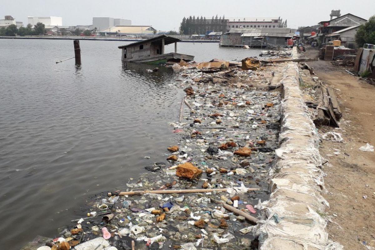Sampah berceceran di tepian tanggul pengaman pantai di Muara Baru, Jakarta Utara, Selasa (11/12/2018).