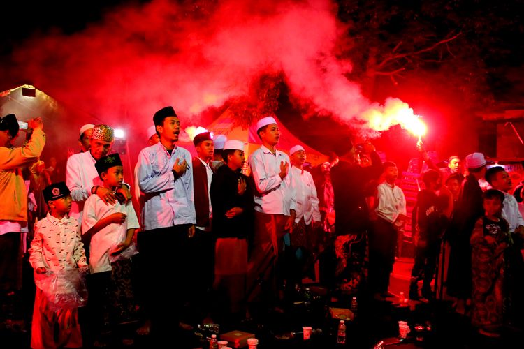 Masyarakat menyanyikan lagu Padamu Negeri usai doa bersama memperingati 1 tahun Tragedi Kanjuruhan yang diadakan Curva Sud di Jalan Patimura Kota Malang, Sabtu (30/9/2023) malam.