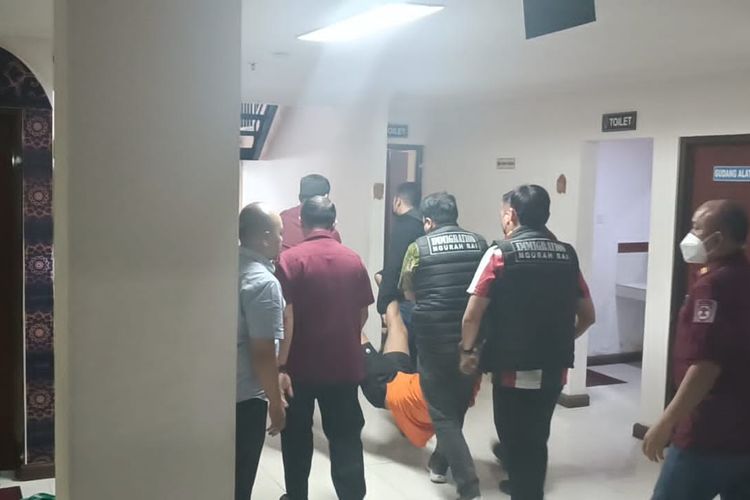 AF (34), saat digotong petugas lantaran mengamuk saat hendak dihadirkan dalam konferensi di di Kantor Imigrasi Kelas I TPI Ngurah Rai, Kabupaten Badung, Provinsi Bali, pada Kamis (15/8/2024). Kompas.com/ Yohanes Valdi Seriang Ginta