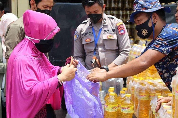 Seorang ibu-ibu membeli minyak goreng dalam pasar murah yang digelar di halaman Polresta Banjarmasin pada, Rabu (9/3/2022). 