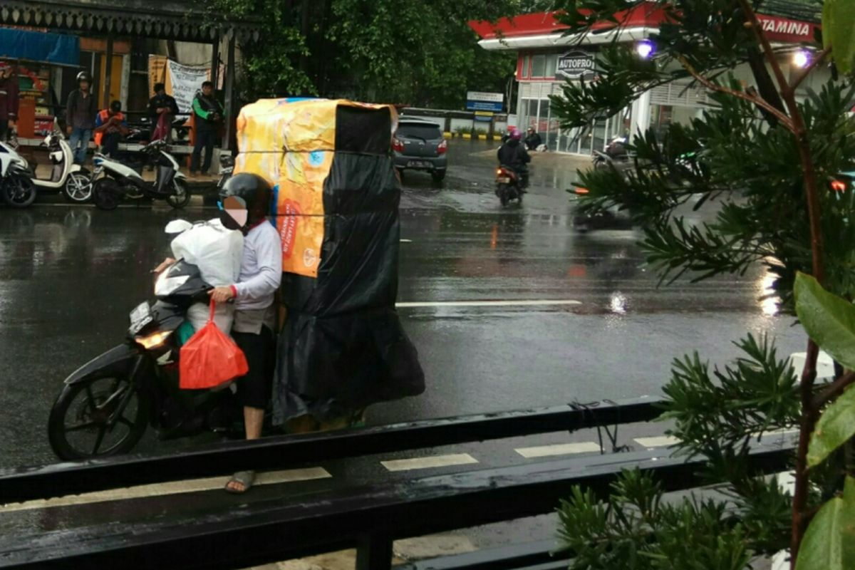 Pengendara motor membawa barang besar berjalan melawan arus di Jalan Ciputat Raya, Jakarta Selatan, Rabu (29/11/2017).