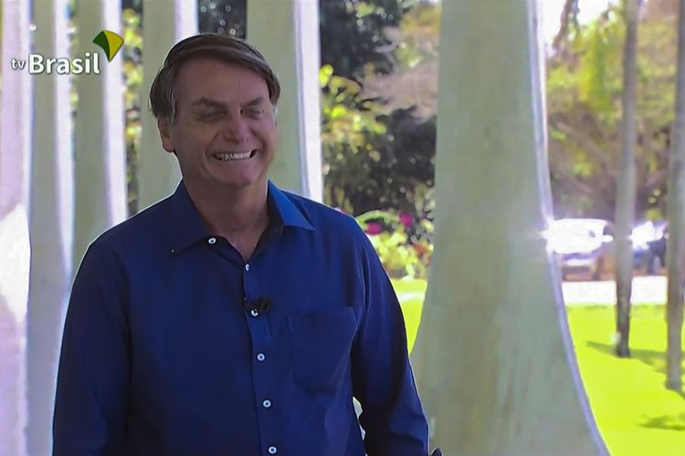 Tayangan dari TV Brasil menampilkan Presiden Brasil Jair Bolsonaro tersenyum di istana kepresidenan Planalto Palace di Brasilia, pada Selasa (7/7/2020). Di hari itu Bolsonaro dinyatakan positif Covid-19, tapi mengaku dirinya baik-baik saja serta hanya mengalami gejala ringan.