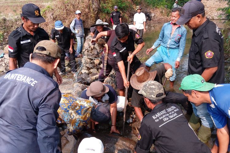 Warga Desa Cibadak, Kecamatan Cibeber, Kabupaten Cianjur, Jawa Barat bahu membahu membangun tanggul darurat akibat jaringan irigasi jebol.