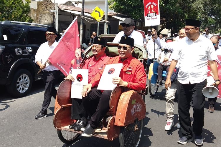 Bakal calon wali kota (Cawali) dan wakil wali kota (Cawawali) Achmad Purnomo-Teguh Prakosa menaiki becak kembalikan formulir penugasan ke DPC PDIP Surakarta Jalan Hasanudin No 26, Purwosari, Laweyan, Solo, Jawa Tengah, Senin (23/9/2019).