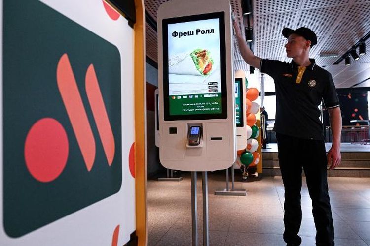 Seorang pekerja sedang membersihkan mesin pemesanan di salah satu cabang restoran McDonald's versi Rusia, yang baru dibuka di Moskwa.