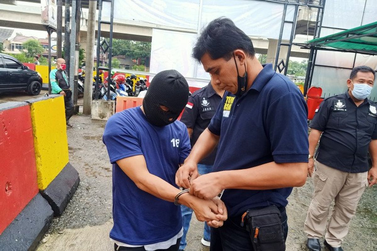 Polisi memborgol lengan tersangka kasus eksibisionis di Mapolsek Duren Sawit, Jakarta Timur, Kamis (21/1/2021). Aksi pelecehan seksual itu dilakukan tersangka kepada istri komedian Isa Bajaj berinisial RM. 