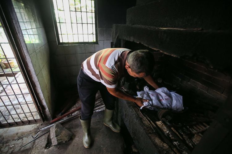 Tukidjo membawa jasad anjing dibungkus kain untuk proses kremasi di Pondok Pengayom Satwa, Jakarta Selatan, Selasa (2/4/2019). Selain krematorium di tempat ini terdapat sekitar 700 makam hewan peliharaan serta shelter hewan.