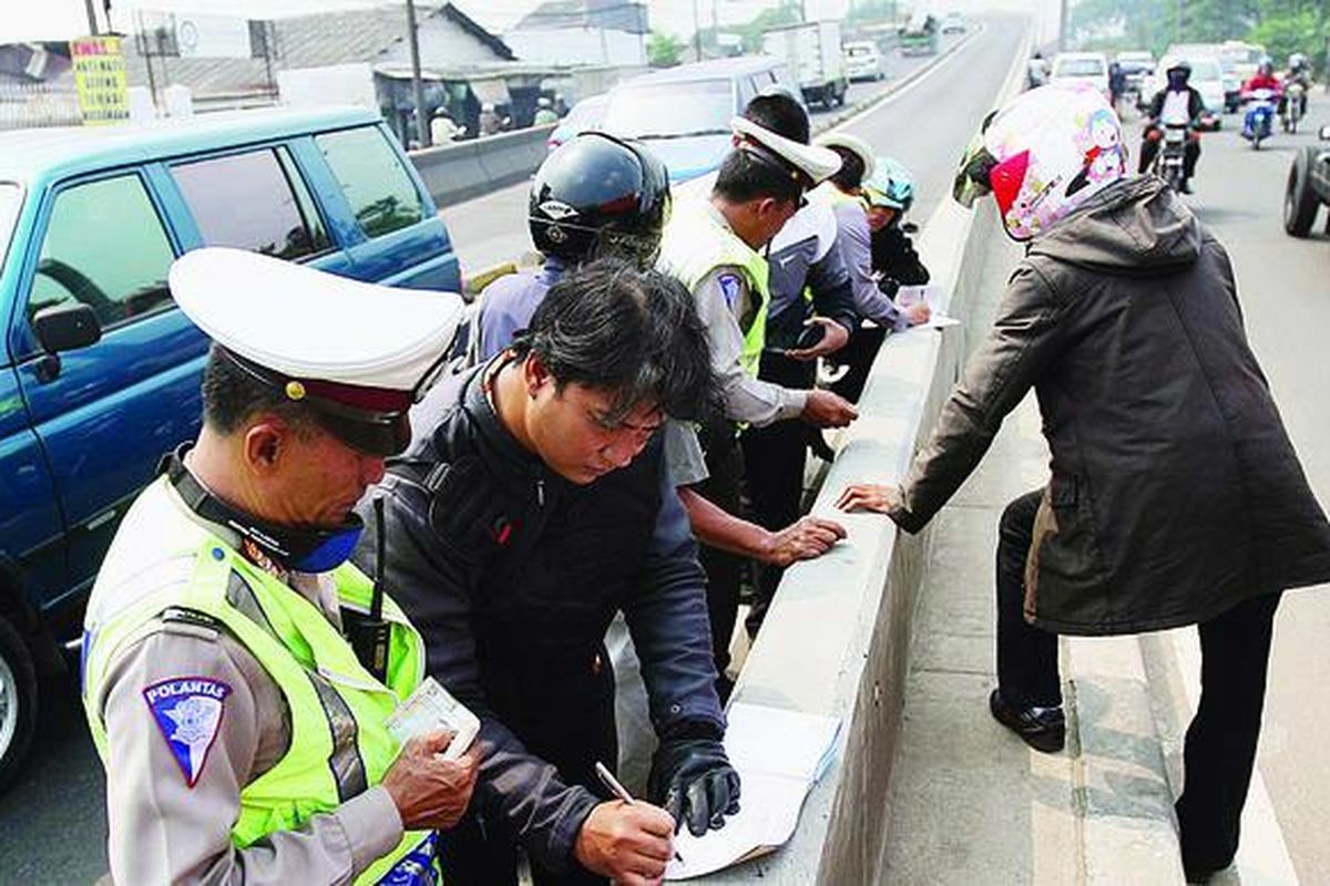 Polisi menulis surat tilang bagi pengendara sepeda motor yang melintas di Jembatan Layang Pesing, Jakbar, Selasa (3/8). Sidang ribuan pelanggar lalu lintas yang sebagian besar terjaring dalam operasi sterilisasi jalur bus transjakarta itu dilakukan di pengadilan mulai hari ini.