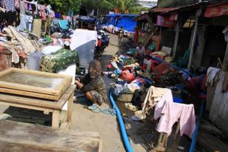 Dua perempuan di Kelurahan Ketang Baru sedang membersihkan pakaian dan perabot rumah tangga lainnya yang diterjang banjir pada Rabu (15/1/2014).
